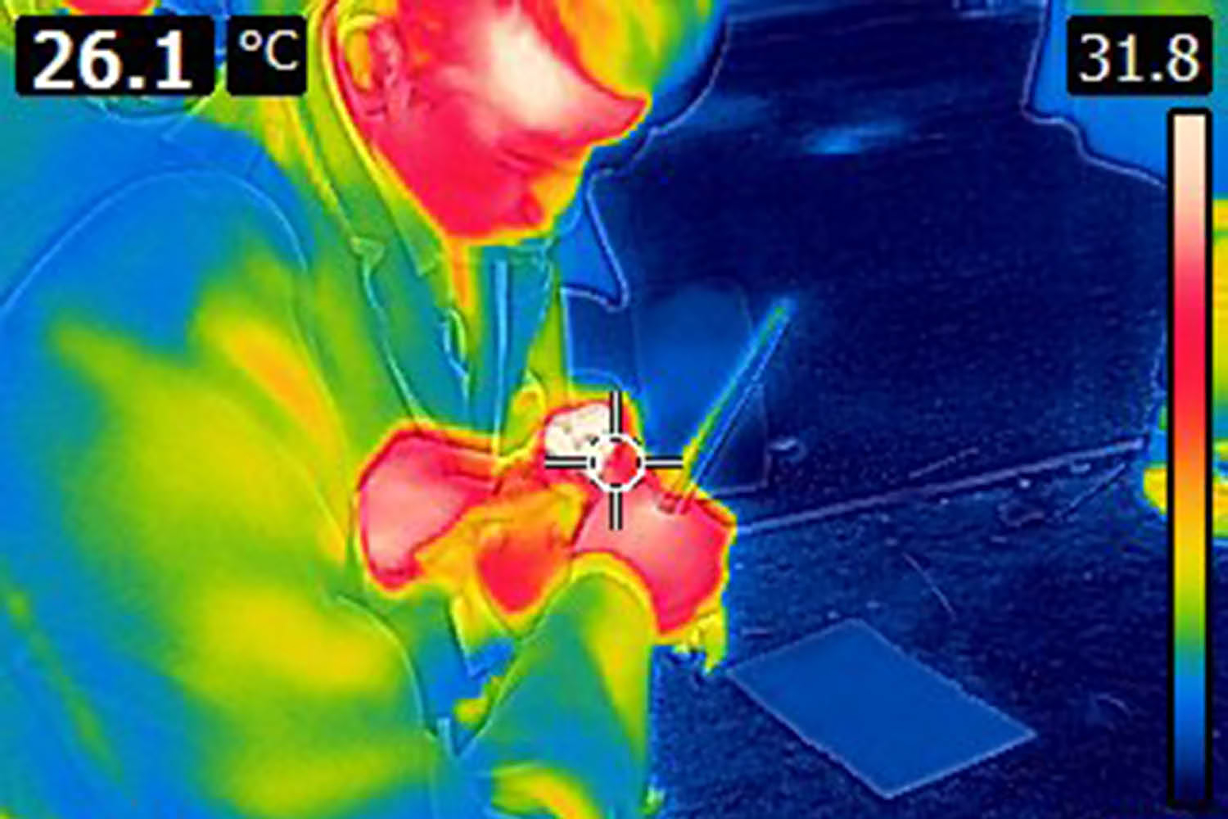 A thermographic photograph of two people starting a fire without matches.
