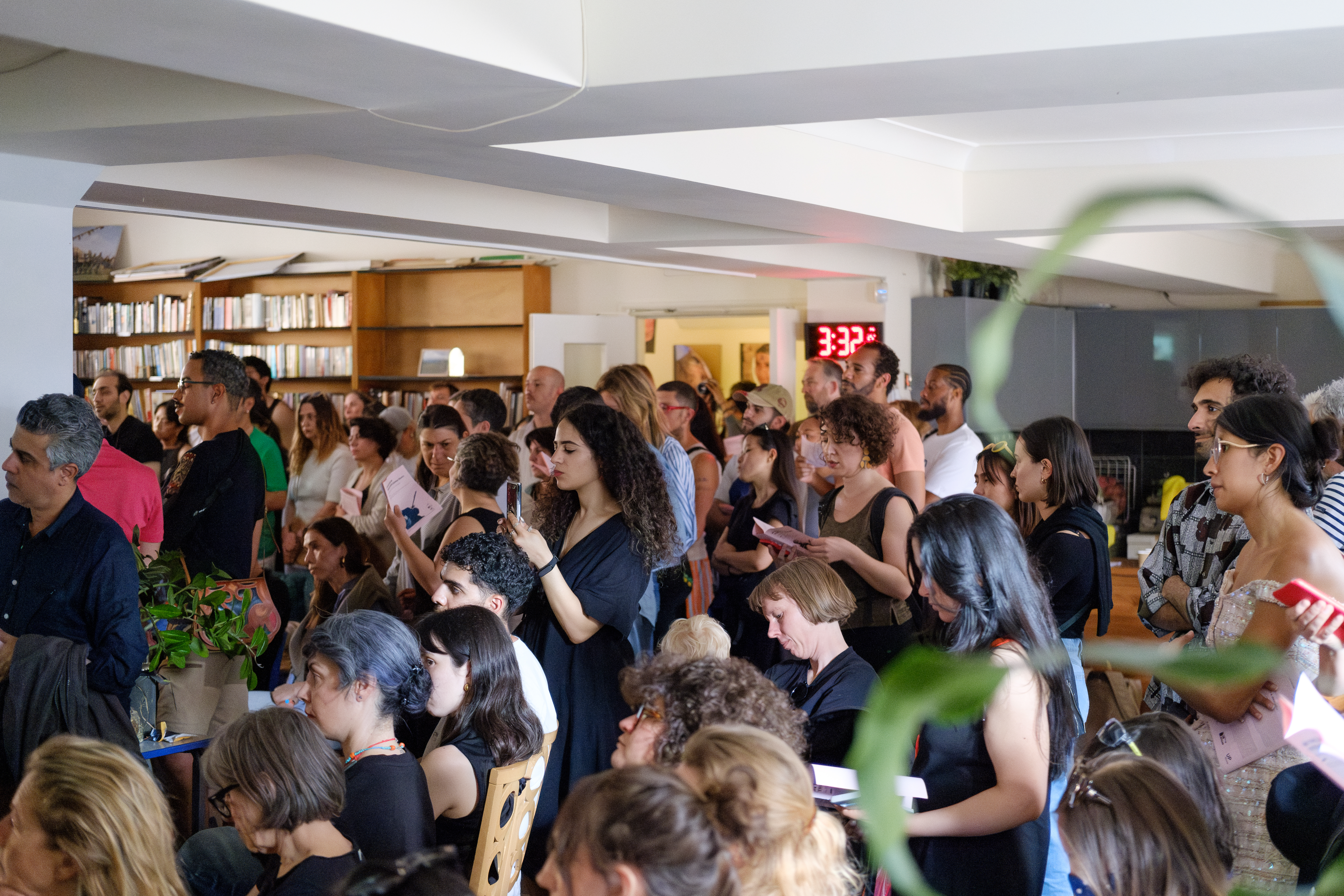 A crowded audience in a room within a community centre.