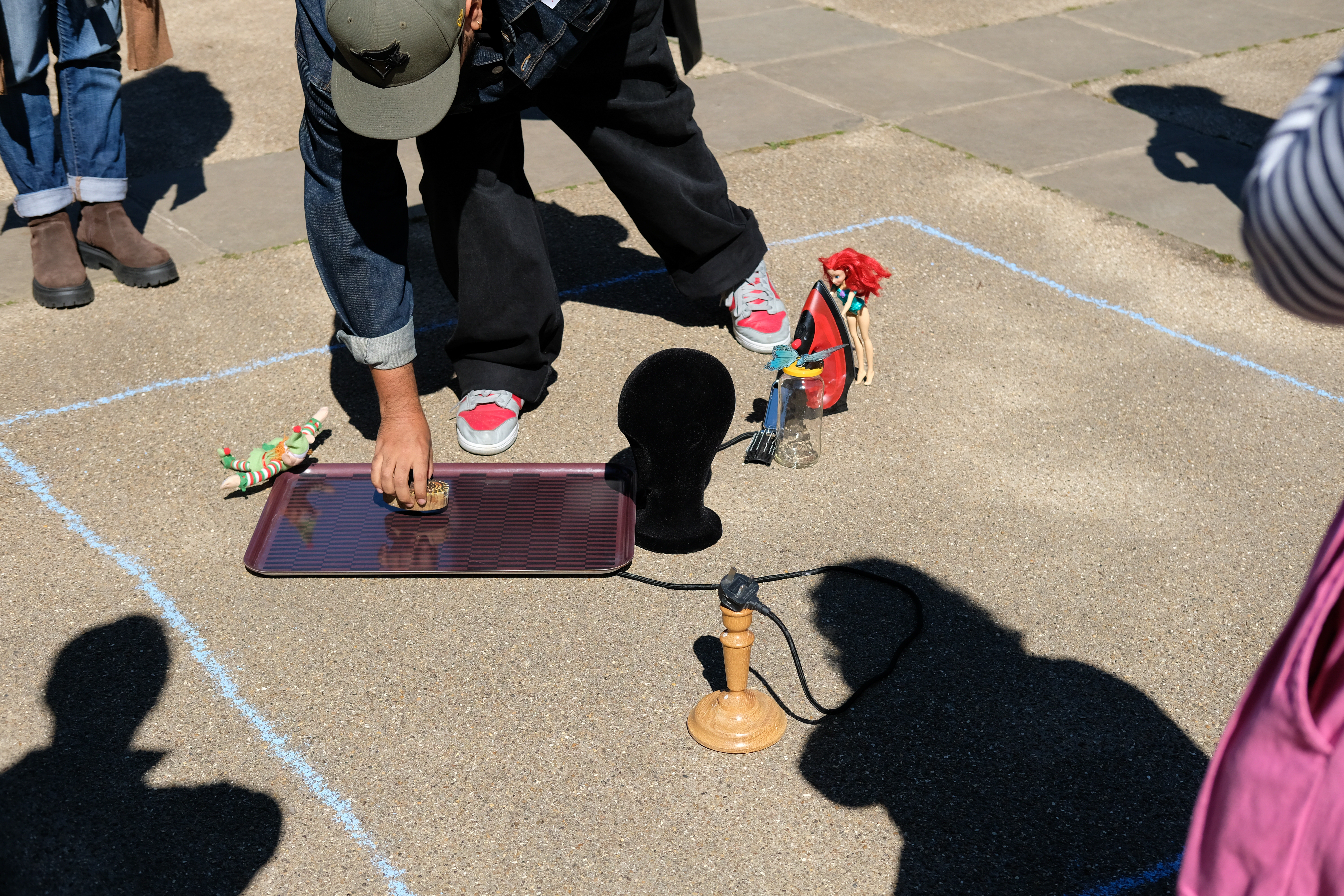 Sculptire being made on the ground outside from household objects