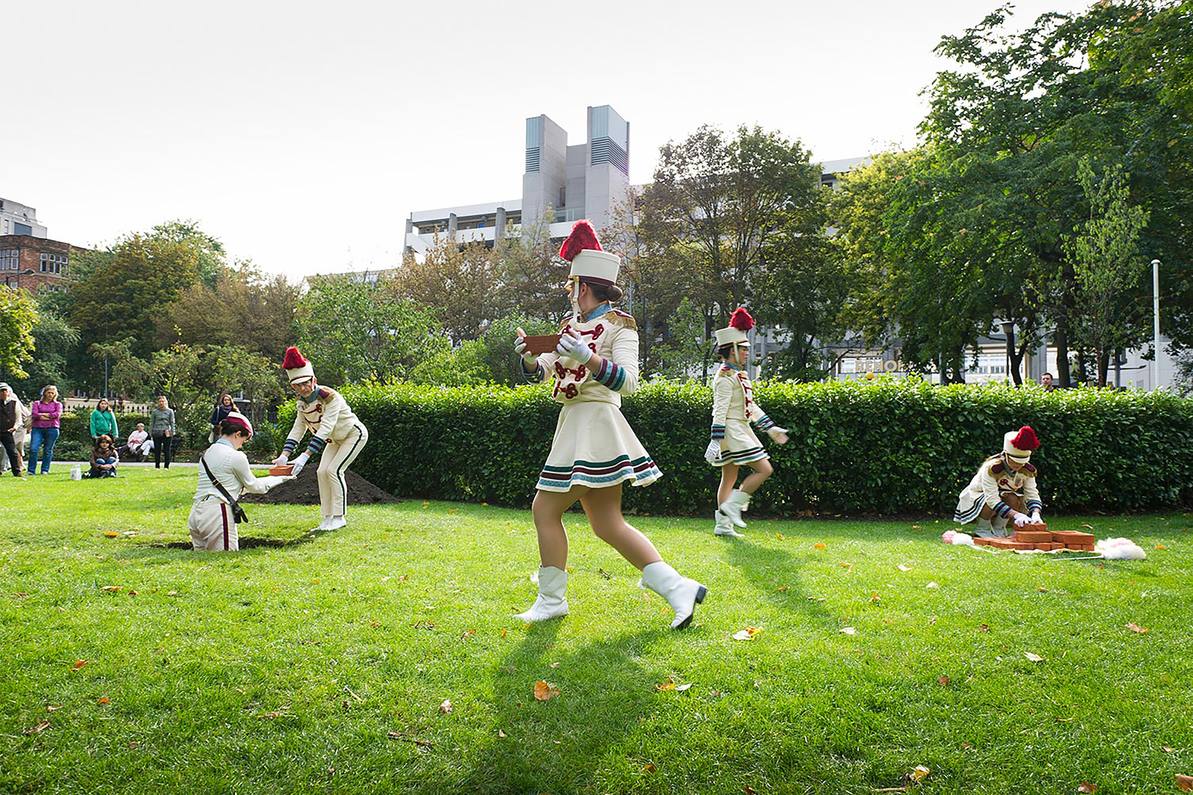 A photograph of performers singing and dancing in front of a crowd.