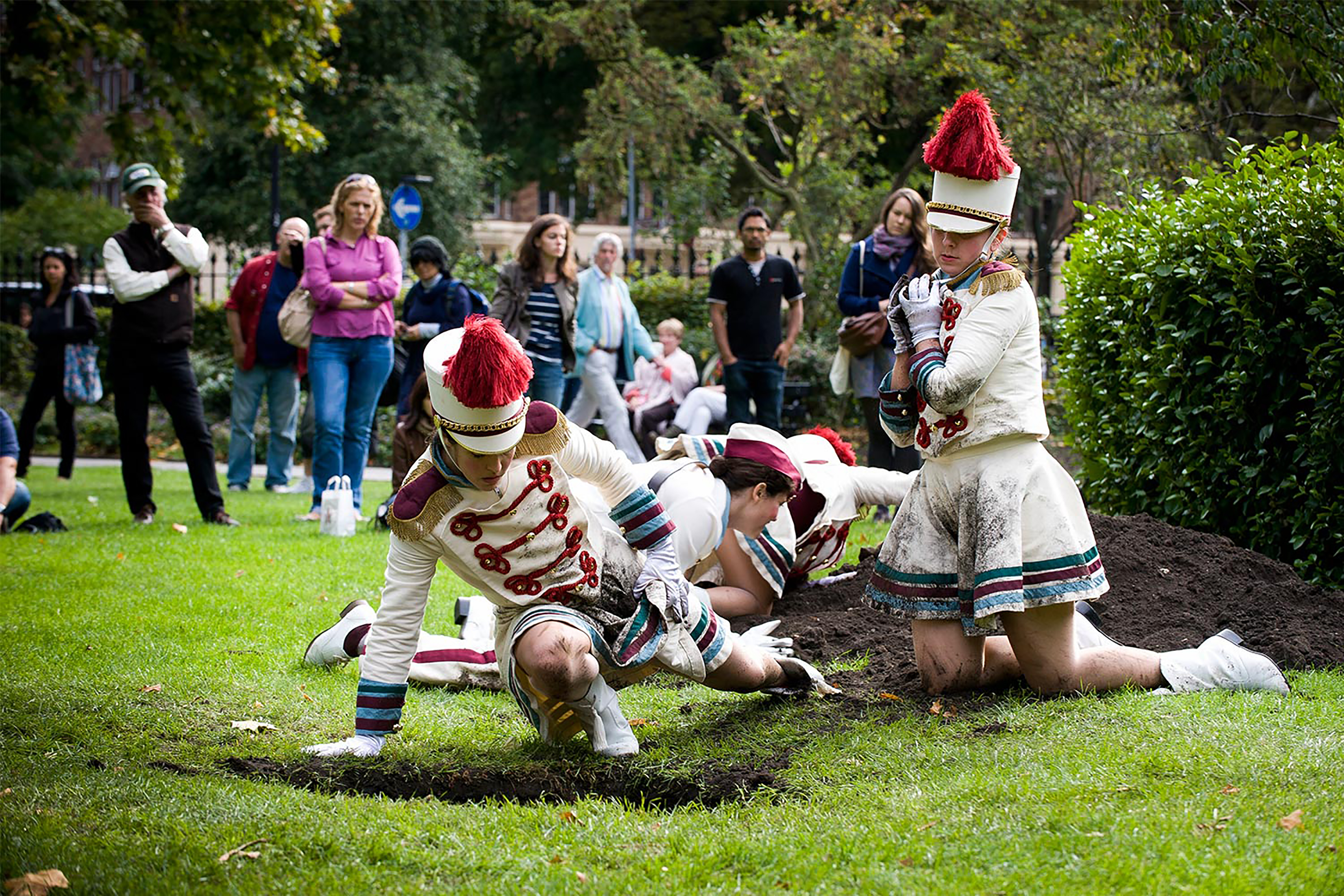 A photograph of performers singing and dancing in front of a crowd.