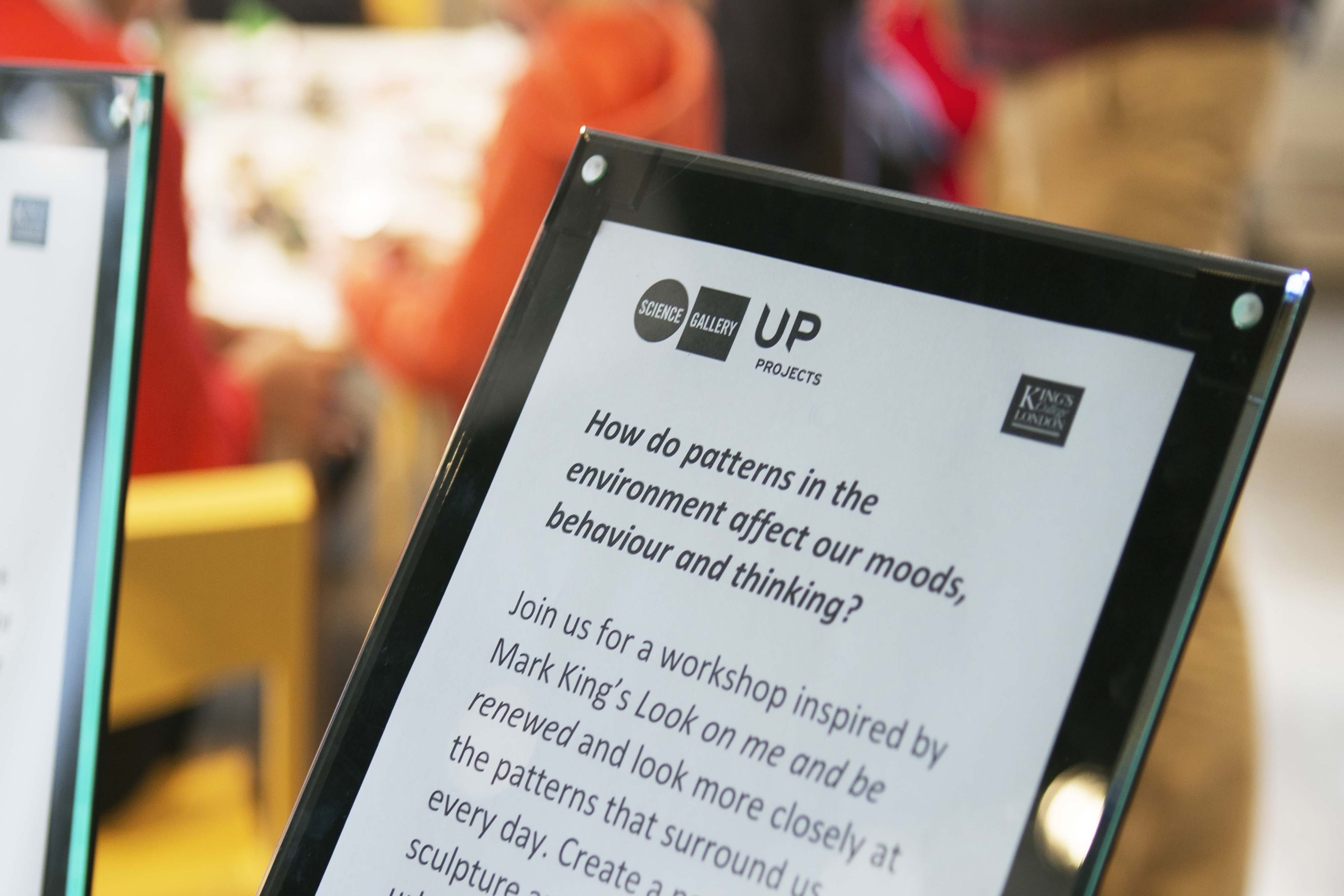 A close up of a plaque in a gallery on a black stand.