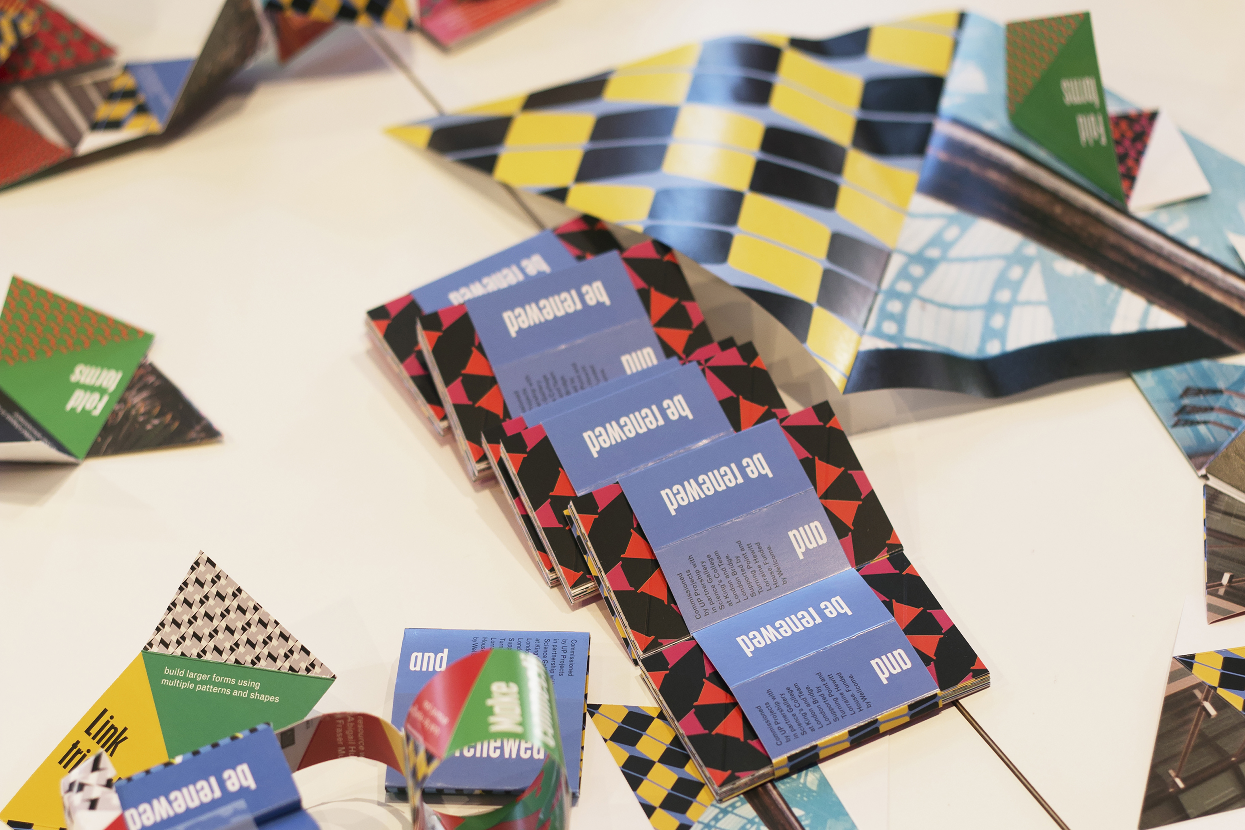 A pile of colourful children’s activity packs all with bright patterned colours on a table.