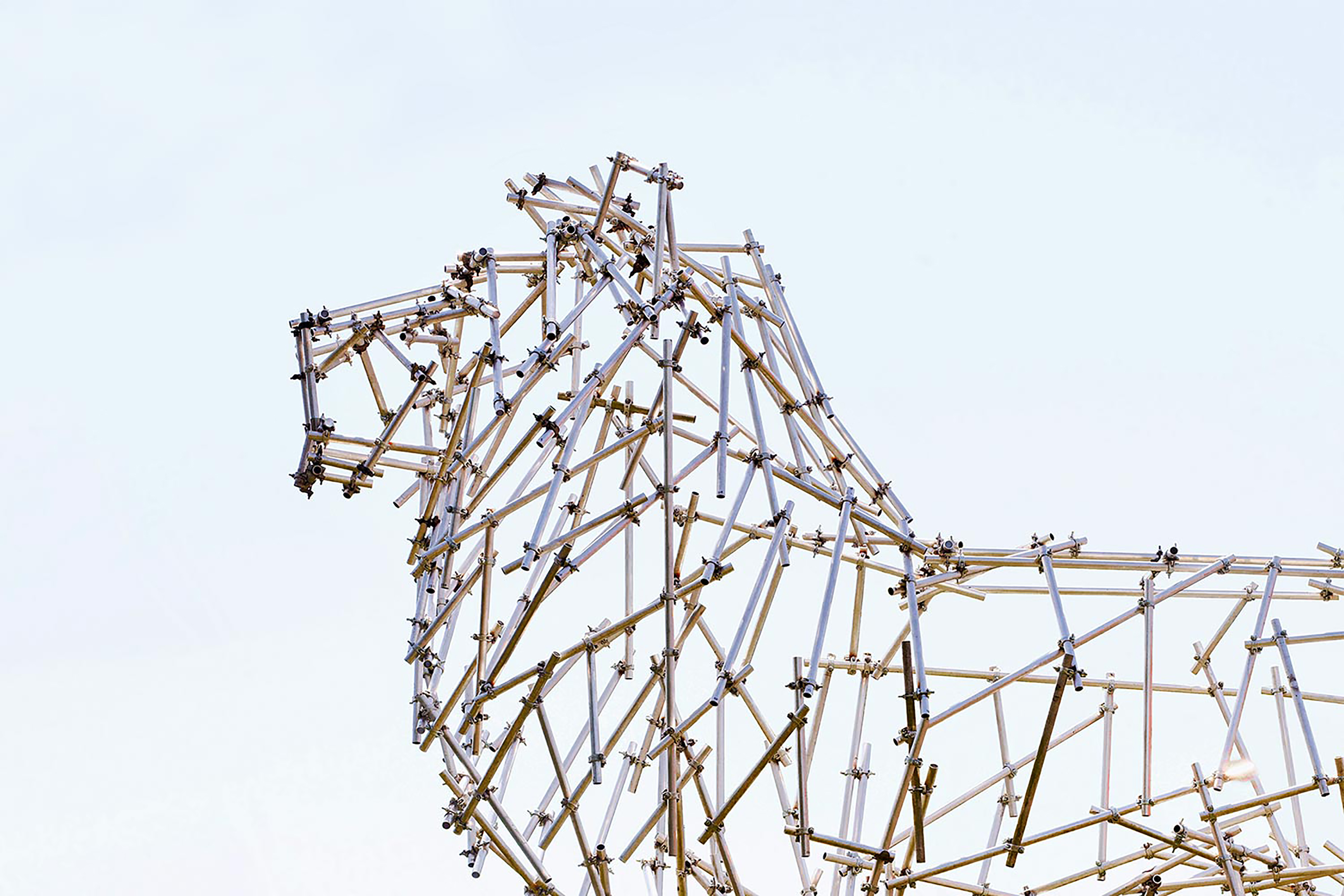 A large structure of a lion made up from small metal poles.